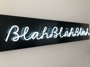 Neon sign in cursive text that says "blah, blah, blah"